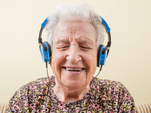 Senior woman listening to music with blue headphones