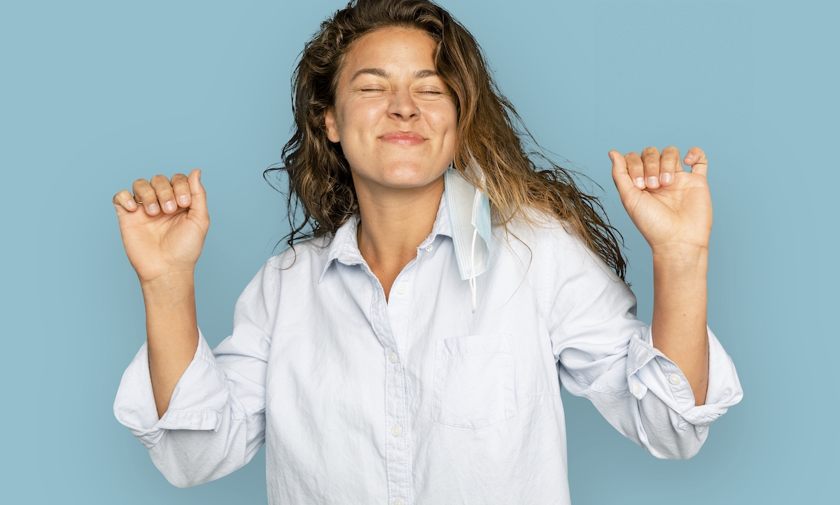 A joyful woman dancing on blue background